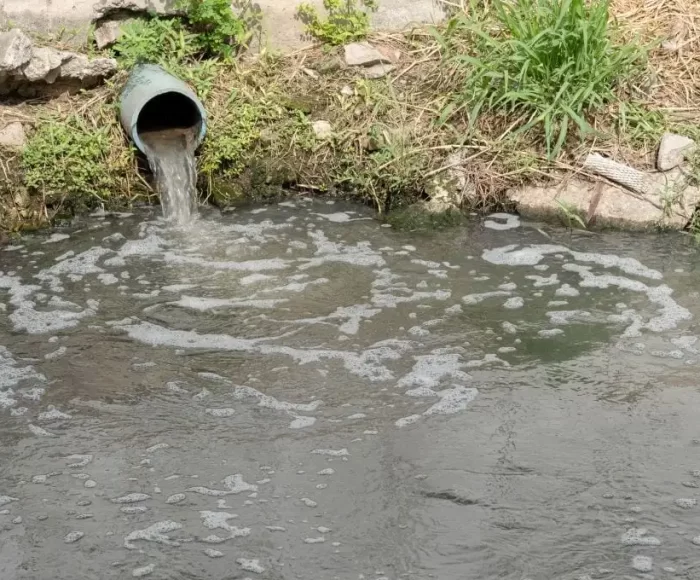 Wastewater discharging from a pipe into a natural water body
