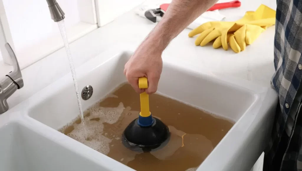 Plunging a utility sink, managing clogged grey water.
