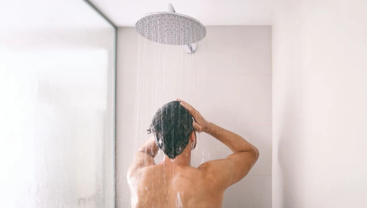 Man showering, using water that can be reused as grey water.